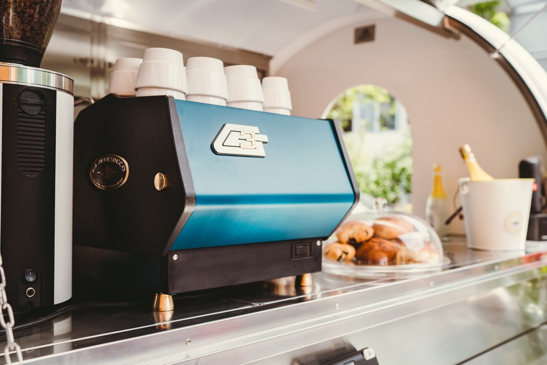 Blaue Espressomaschine und Gebäck hinter der Theke von Emmas Kaffeewagen
