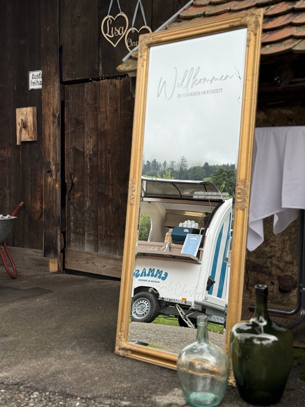 Emmas Kaffeewagen spiegelt sich in einem goldenen Willkommensspiegel bei einer Hochzeit